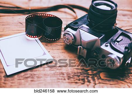 Stock Photo - Cameras on wooden table with film and photograph. Fotosearch