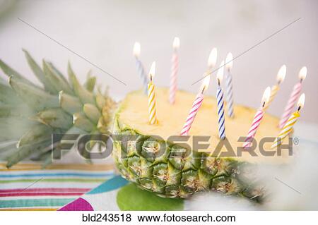 Stock Photo - Candles burning in half of sliced pineapple. Fotosearch