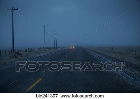 Stock Photo - Car approaching on icy two-lane road. Fotosearch