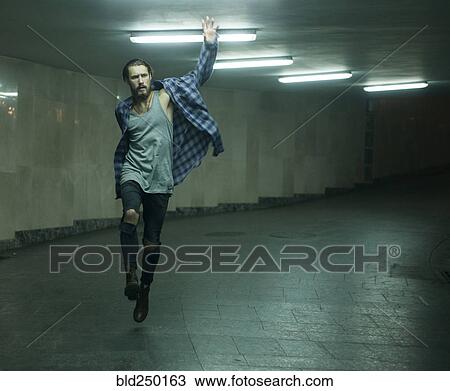 Carefree Caucasian man skipping in tunnel View Large Photo Image Stock Image - Carefree Caucasian man skipping in tunnel. Fotosearch