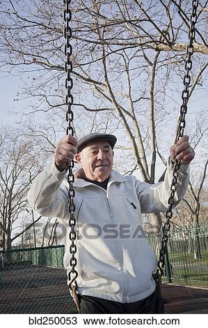 Carefree Hispanic man on swing in park View Large Photo Image Stock Image - Carefree Hispanic man on swing in park. Fotosearch
