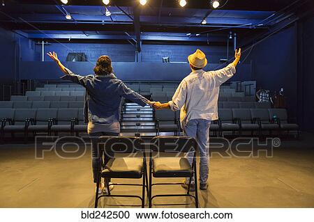 Caucasian actors rehearsing waving in theater View Large Photo Image Stock Image - Caucasian actors rehearsing waving in theater. Fotosearch