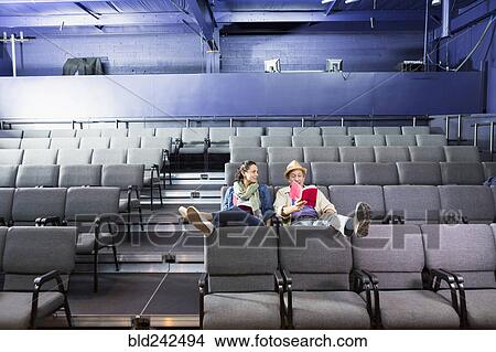 Caucasian actors sitting in audience with scripts in theater View Large Photo Image Picture - Caucasian actors sitting in audience with scripts in theater. Fotosearch