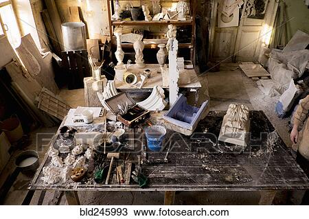 Stock Image - Caucasian artist in messy studio. Fotosearch