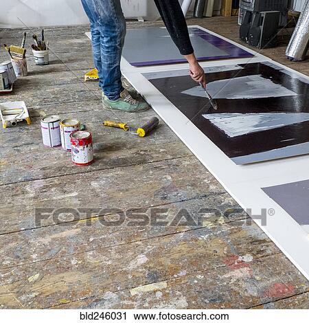 Stock Image - Caucasian artist painting with paintbrush. Fotosearch