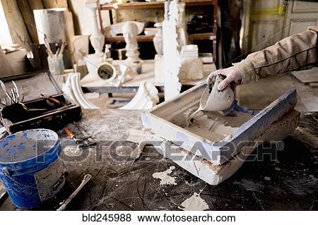 Caucasian artist pouring plaster into mold View Large Photo Image Stock Photo - Caucasian artist pouring plaster into mold. Fotosearch