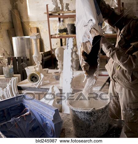 Caucasian artist pouring plaster mix into bucket View Large Photo Image Stock Photo - Caucasian artist pouring plaster mix into bucket. Fotosearch