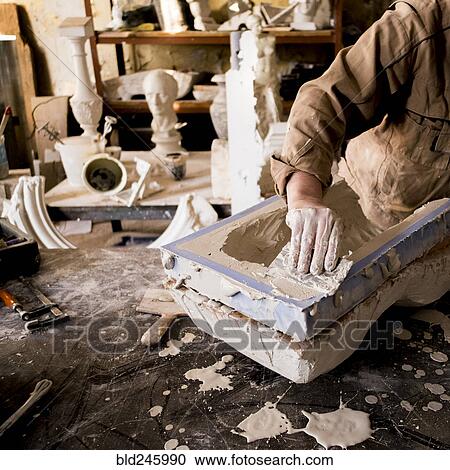 Caucasian artist scraping plaster in mold View Large Photo Image Stock Image - Caucasian artist scraping plaster in mold. Fotosearch