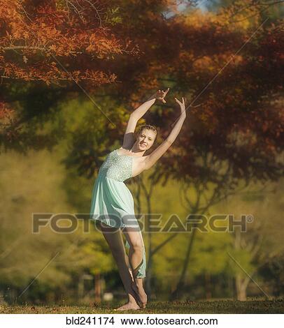 Caucasian ballerina dancing under branches in park View Large Photo Image Picture - Caucasian ballerina dancing under branches in park. Fotosearch