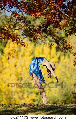 Caucasian ballerina dancing under branches in park View Large Photo Image Stock Image - Caucasian ballerina dancing under branches in park. Fotosearch