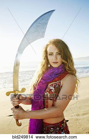 Caucasian belly dancer holding sword on beach View Large Photo Image Picture - Caucasian belly dancer holding sword on beach. Fotosearch