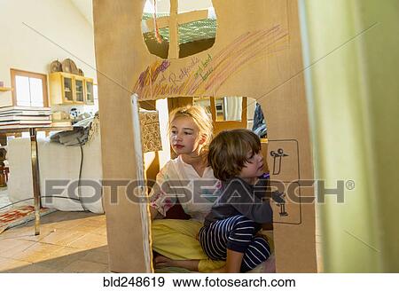Stock Photo - Caucasian boy and girl playing in cardboard house. Fotosearch