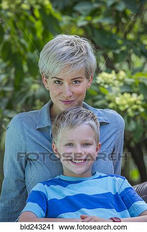 Stock Image - Caucasian boy leaning on mother outdoors. Fotosearch