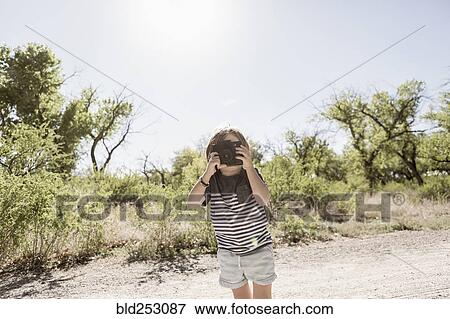 Caucasian boy photographing with camera on dirt path View Large Photo Image Stock Photo - Caucasian boy photographing with camera on dirt path. Fotosearch