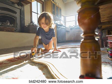 Caucasian boy playing with toy race track on floor View Large Photo Image Stock Image - Caucasian boy playing with toy race track on floor. Fotosearch
