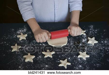 Stock Image - Caucasian boy rolling cookie dough. Fotosearch