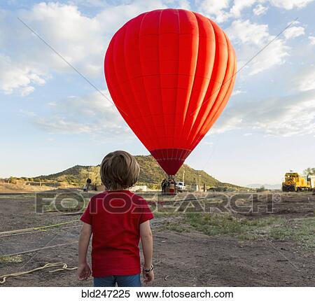 Caucasian boy watching distant hot air balloon View Large Photo Image Stock Photography - Caucasian boy watching distant hot air balloon. Fotosearch
