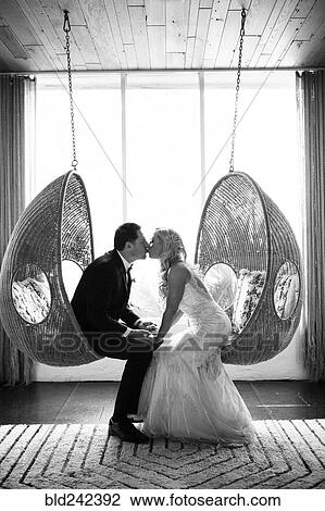 Caucasian bride and groom kissing in hanging chairs View Large Photo Image Stock Image - Caucasian bride and groom kissing in hanging chairs. Fotosearch