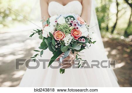 Caucasian bride holding bouquet of flowers outdoors View Large Photo Image Stock Photo - Caucasian bride holding bouquet of flowers outdoors. Fotosearch