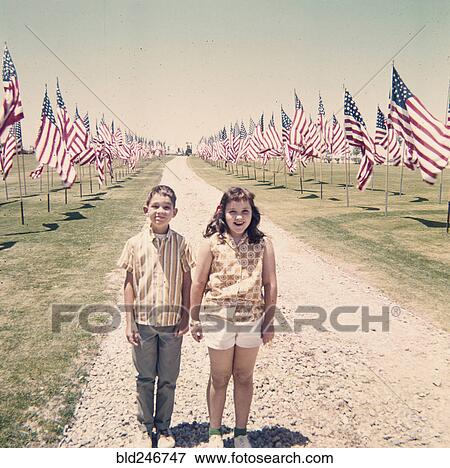 Stock Photo - Caucasian brother and sister holding hands near American flags. Fotosearch