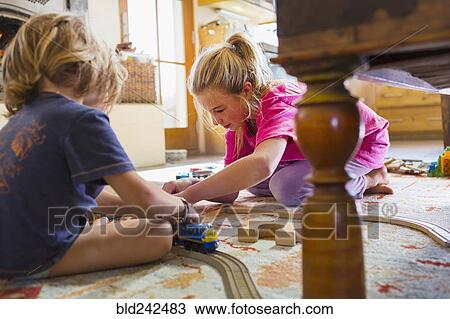 Caucasian brother and sister playing with toy race track on floor View Large Photo Image Stock Image - Caucasian brother and sister playing with toy race track on floor. Fotosearch