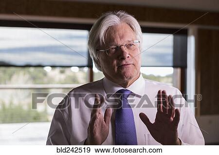 Caucasian businessman gesturing while talking View Large Photo Image Stock Photo - Caucasian businessman gesturing while talking. Fotosearch