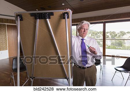 Stock Photo - Caucasian businessman leaning on whiteboard. Fotosearch