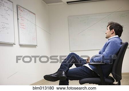 Caucasian businessman looking at whiteboard in conference room View Large Photo Image Stock Image - Caucasian businessman looking at whiteboard in conference room. Fotosearch