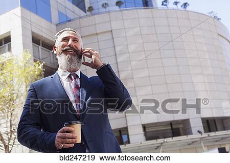 Stock Photo - Caucasian businessman talking on cell phone outdoors. Fotosearch