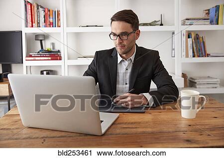 Caucasian businessman using laptop and digital tablet in office View Large Photo Image Stock Image - Caucasian businessman using laptop and digital tablet in office. Fotosearch