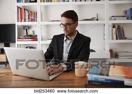 Caucasian businessman using laptop in home office View Large Photo Image Stock Image - Caucasian businessman using laptop in home office. Fotosearch