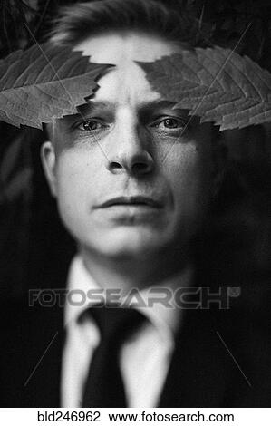 Stock Image - Caucasian businessman with leaves on forehead. Fotosearch