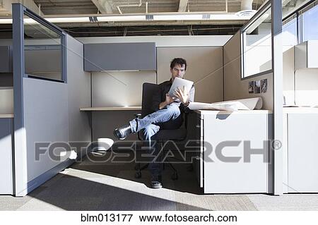 Caucasian businessman working in cubicle View Large Photo Image Stock Photo - Caucasian businessman working in cubicle. Fotosearch