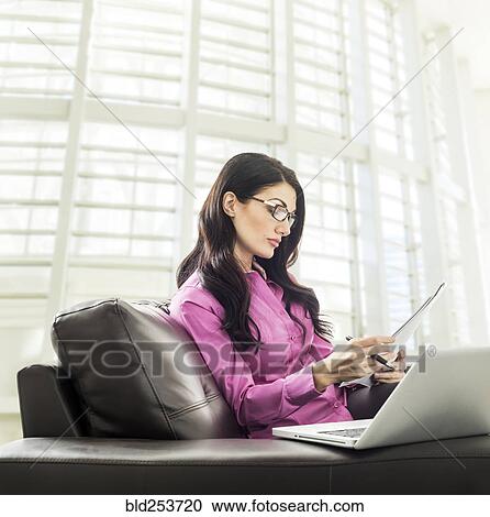 Caucasian businesswoman reading paperwork in lobby View Large Photo Image Stock Image - Caucasian businesswoman reading paperwork in lobby. Fotosearch