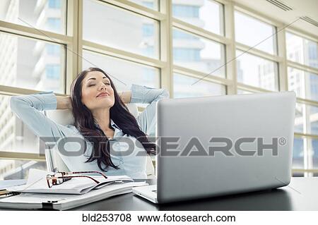 Stock Photo - Caucasian businesswoman unwinding in office. Fotosearch