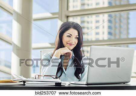 Stock Photo - Caucasian businesswoman using laptop. Fotosearch