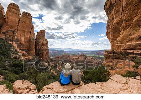 Stock Photo - Caucasian couple admiring scenic view in desert landscape. Fotosearch