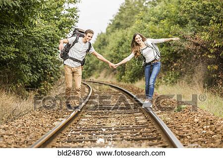 Caucasian couple balancing on train tracks View Large Photo Image Stock Image - Caucasian couple balancing on train tracks. Fotosearch