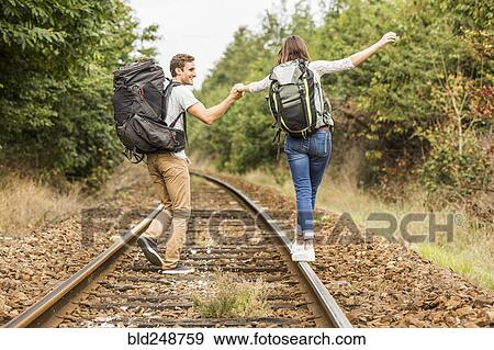 Caucasian couple balancing on train tracks View Large Photo Image Stock Photo - Caucasian couple balancing on train tracks. Fotosearch