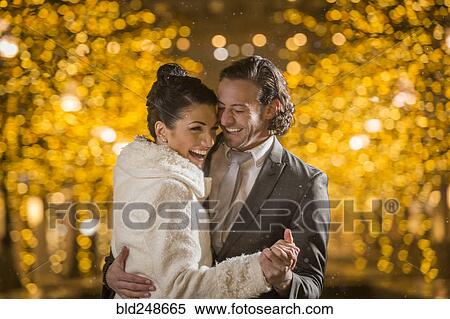 Stock Photography - Caucasian couple dancing outdoors at night. Fotosearch
