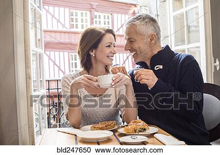 Stock Image - Caucasian couple drinking coffee at breakfast. Fotosearch