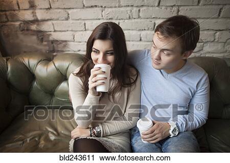 Caucasian couple drinking coffee on sofa View Large Photo Image Stock Image - Caucasian couple drinking coffee on sofa. Fotosearch