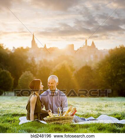 Stock Photograph - Caucasian couple enjoying a picnic in grass. Fotosearch
