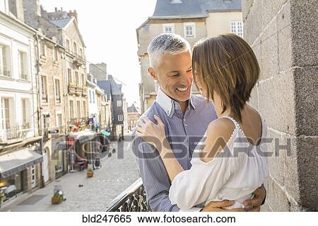 Caucasian couple hogging on balcony in city View Large Photo Image Stock Photography - Caucasian couple hogging on balcony in city. Fotosearch