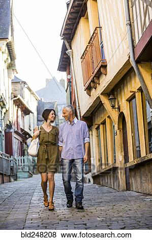 Caucasian couple holding hands walking in city View Large Photo Image Stock Photo - Caucasian couple holding hands walking in city. Fotosearch