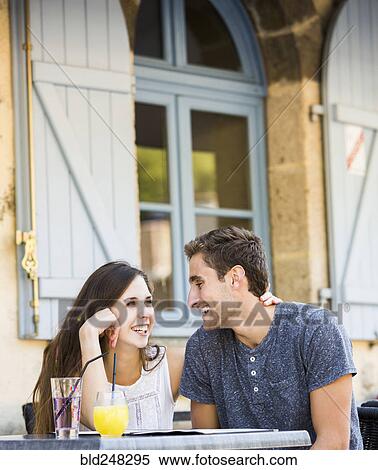 Stock Photography - Caucasian couple hugging at restaurant. Fotosearch