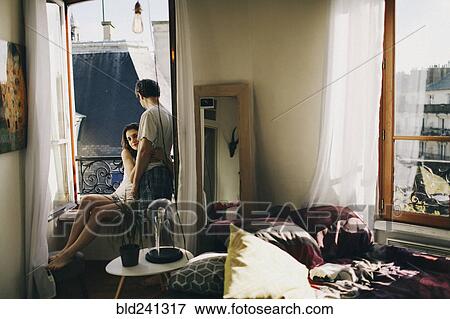 Caucasian couple hugging in apartment window View Large Photo Image Stock Photo - Caucasian couple hugging in apartment window. Fotosearch