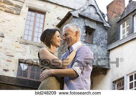 Stock Photo - Caucasian couple hugging in city. Fotosearch