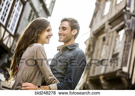 Stock Photo - Caucasian couple hugging in city. Fotosearch