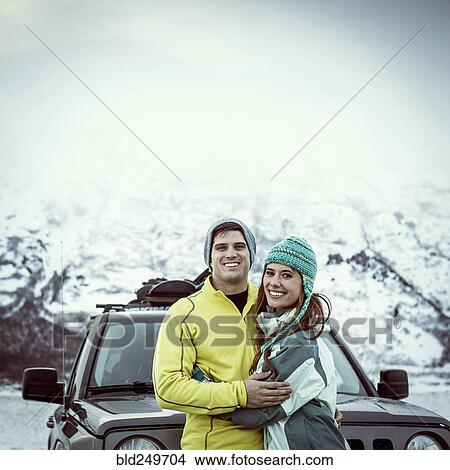 Picture - Caucasian couple hugging near car in winter. Fotosearch